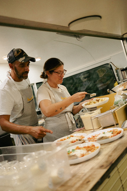 Tommaso and Luisa plating fresh pasta inside the Amaranto food truck