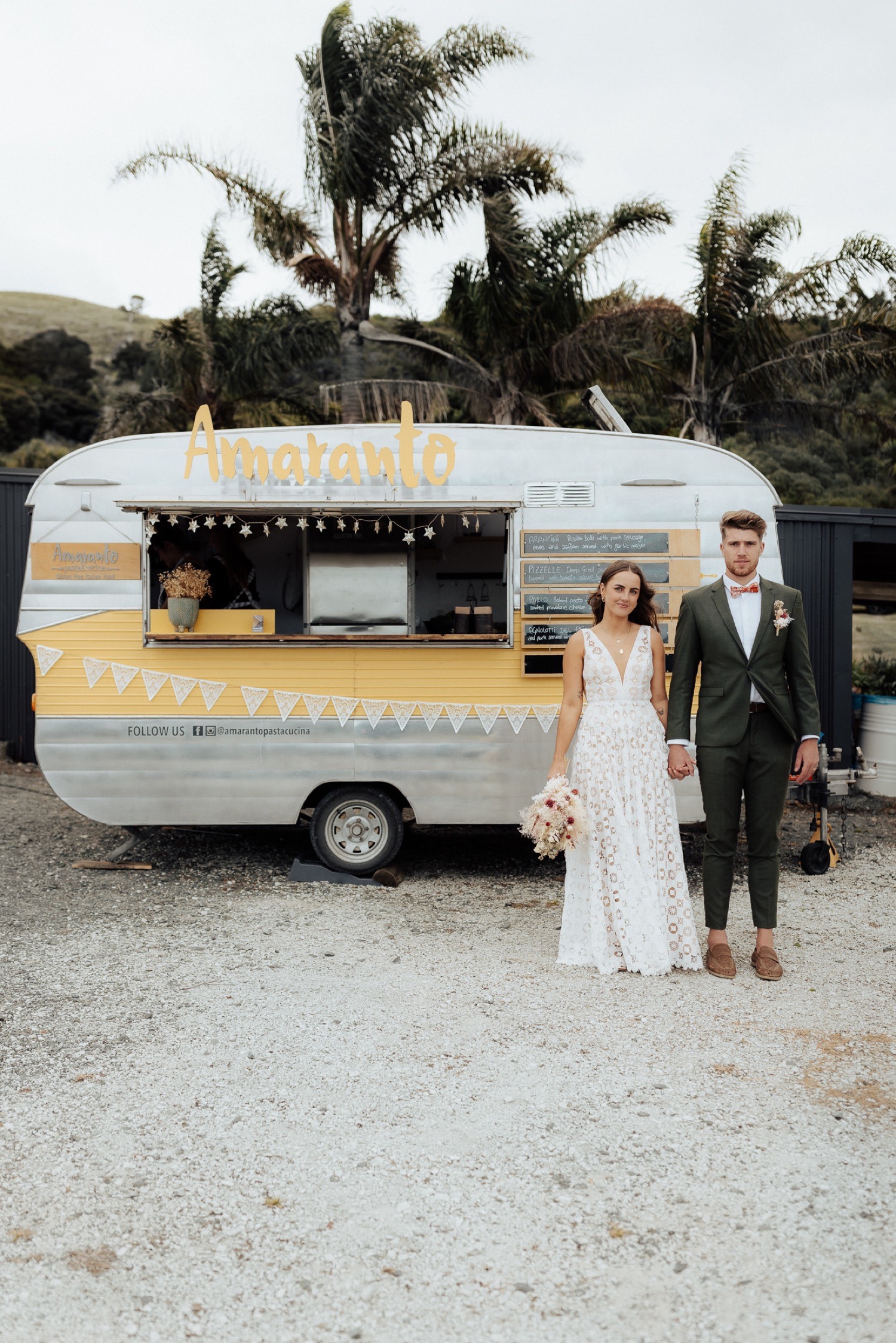 A couple in front of the Amaranto food truck at their wedding