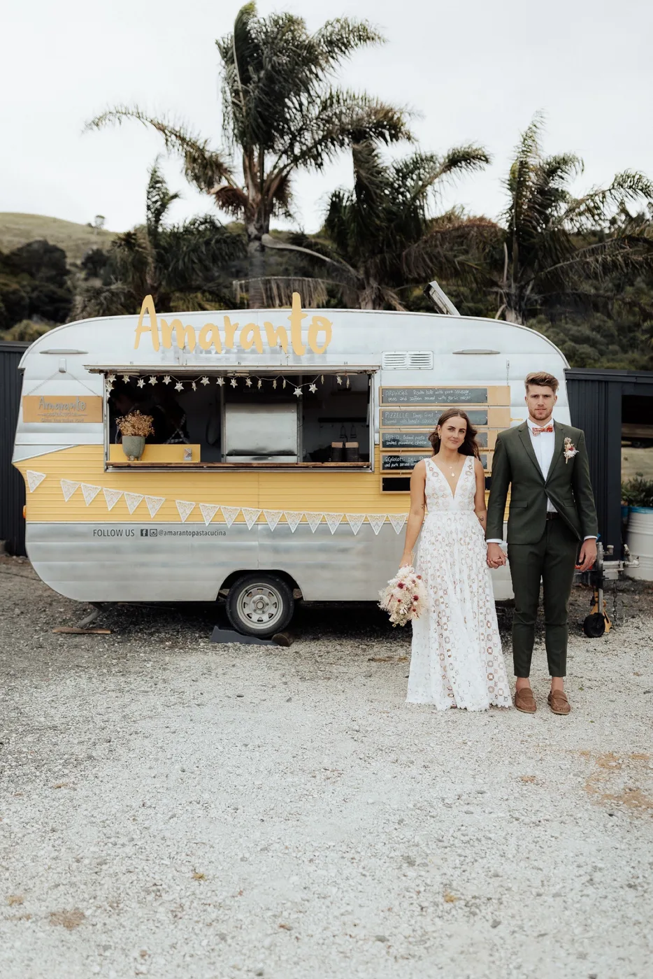 A couple in front of the Amaranto food truck at their wedding