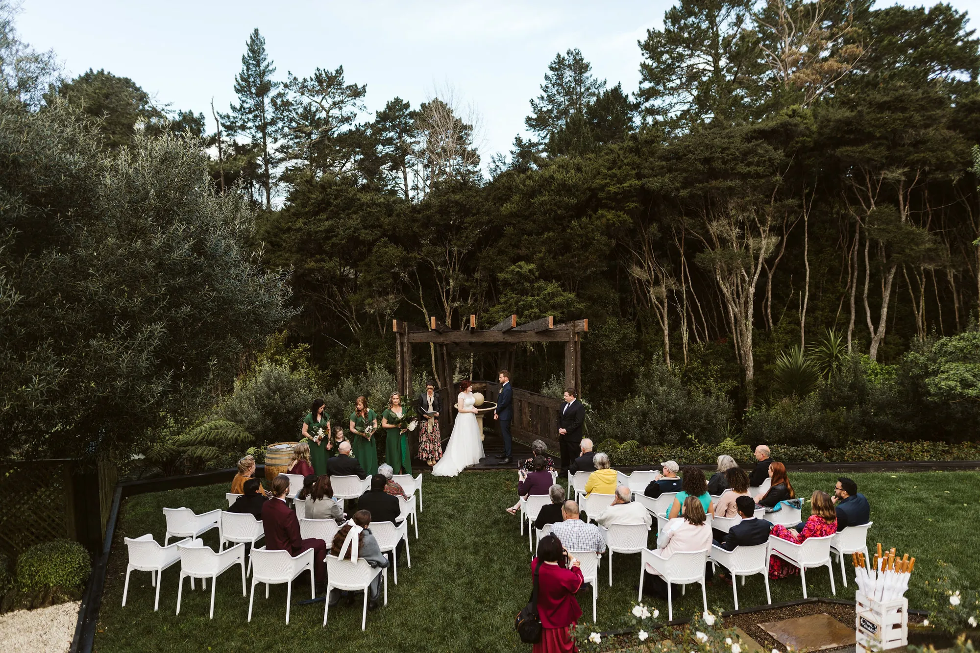 Wide view of Amy and Vince's outdoor ceremony in a garden surrounded by native bush