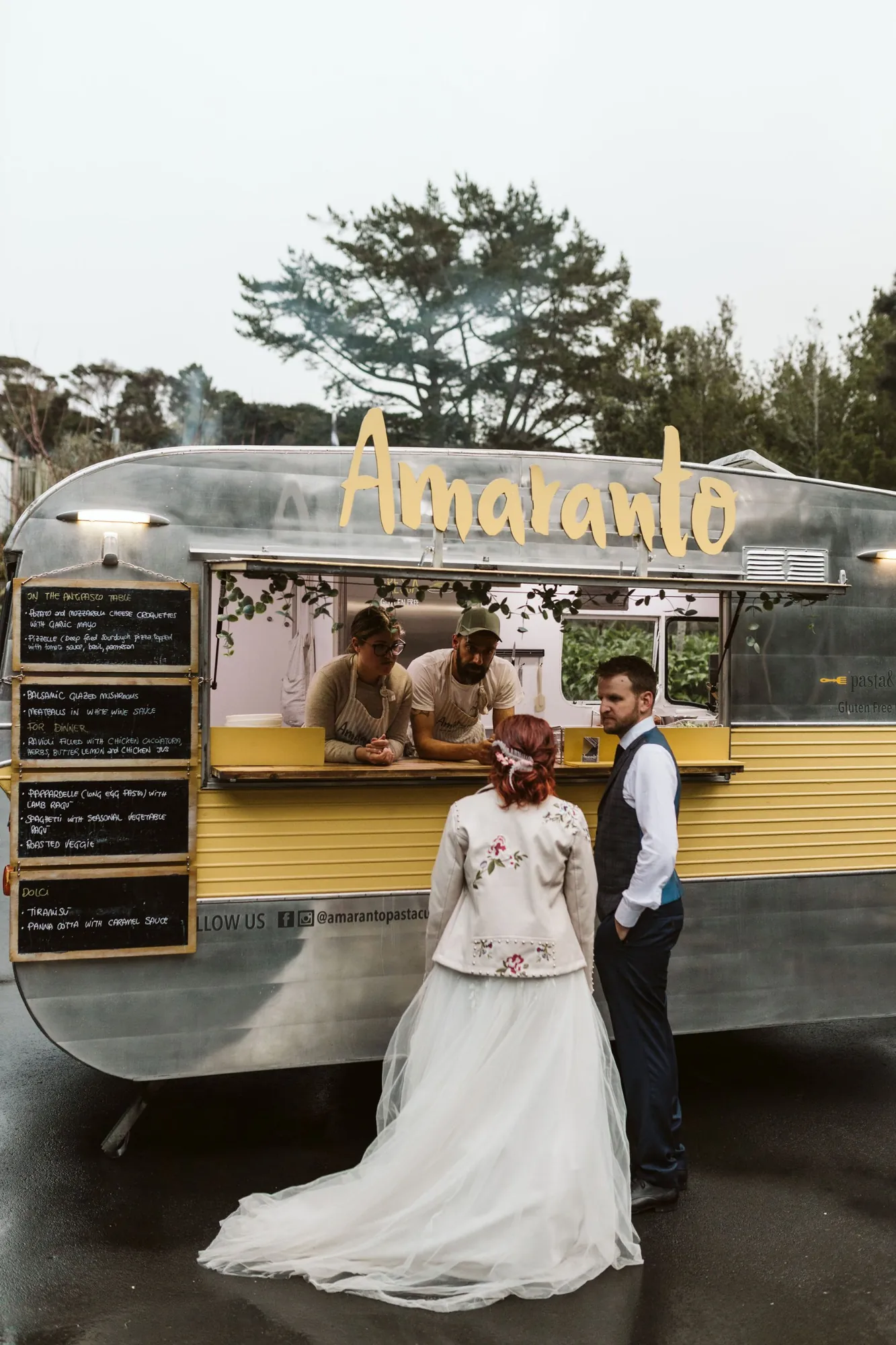 Amy and Vince at the Amaranto caravan hatch, with Luisa and Tommy inside and the menu on chalkboards