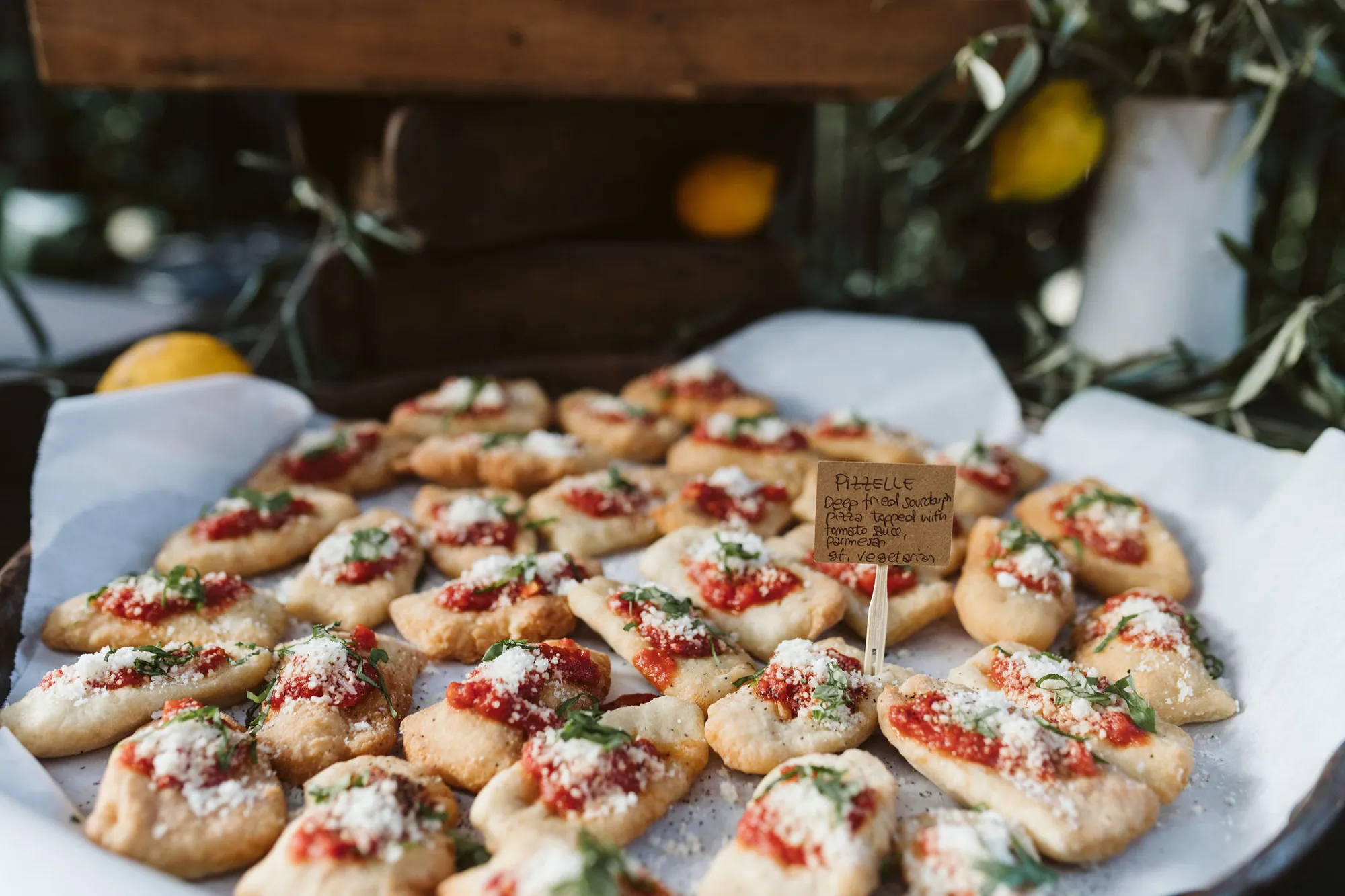 A tray of pizzelle, deep-fried sourdough topped with tomato sauce, basil and parmesan