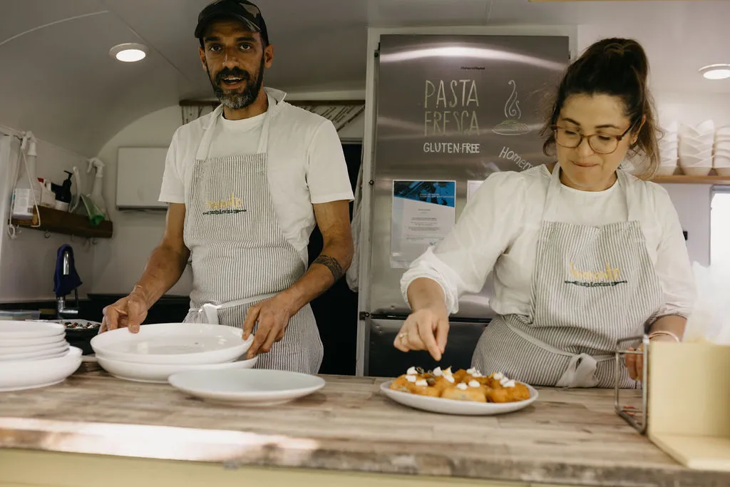 Tommy and Luisa plating arancini inside the Amaranto caravan at Chloe and Mitchell's wedding