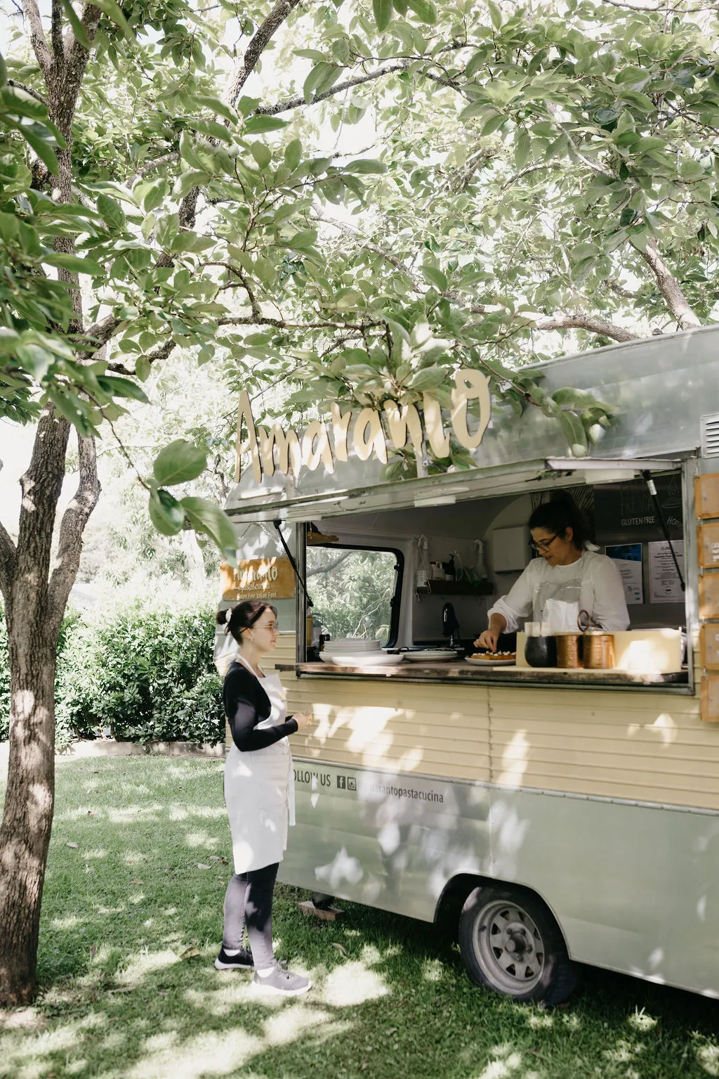 The Amaranto caravan set up under the apple trees at Chloe and Mitchell's Matakana reception