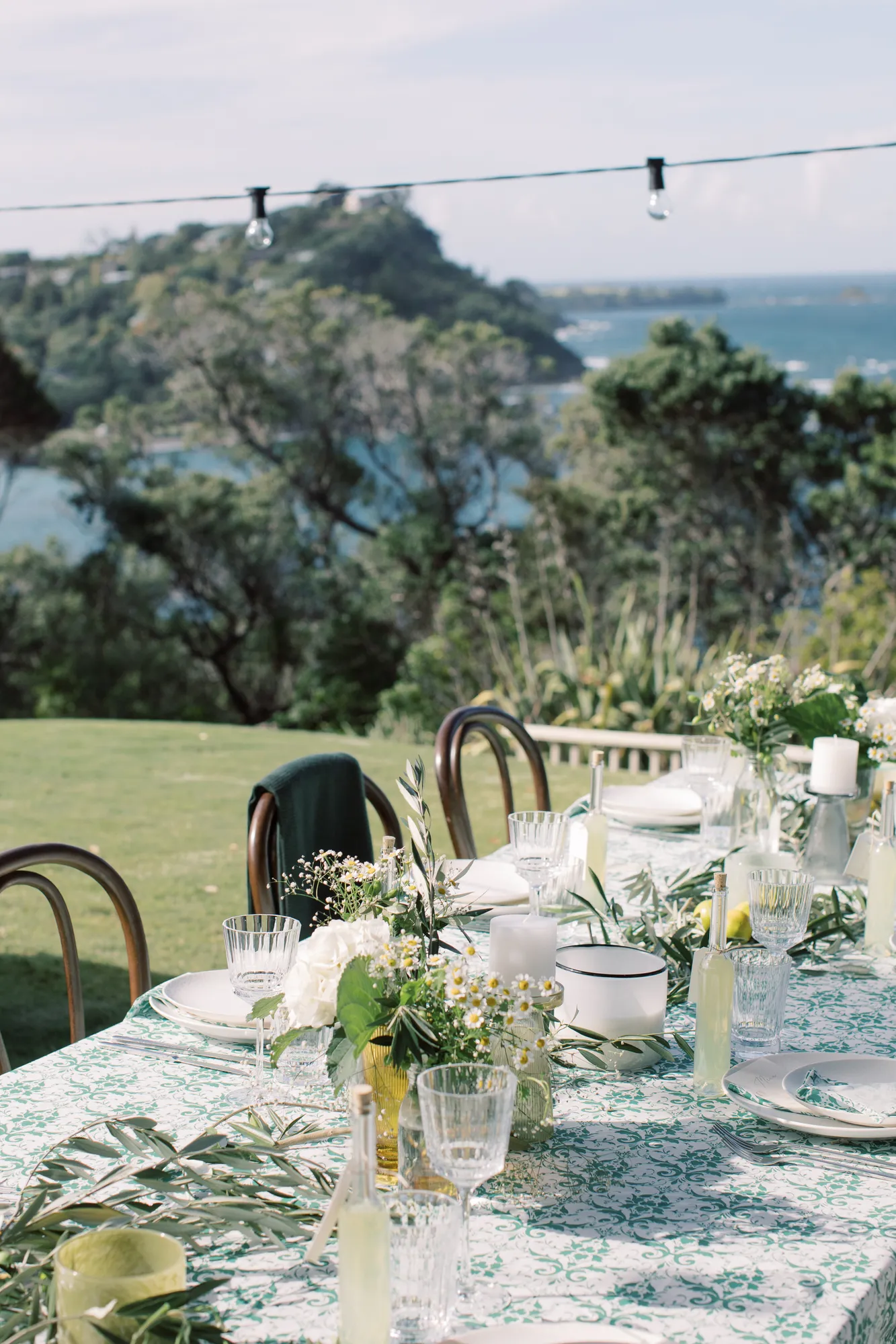 Table detail close-up at Elle and Sam's wedding at Ti Point — green damask cloth with lemons and olive branches