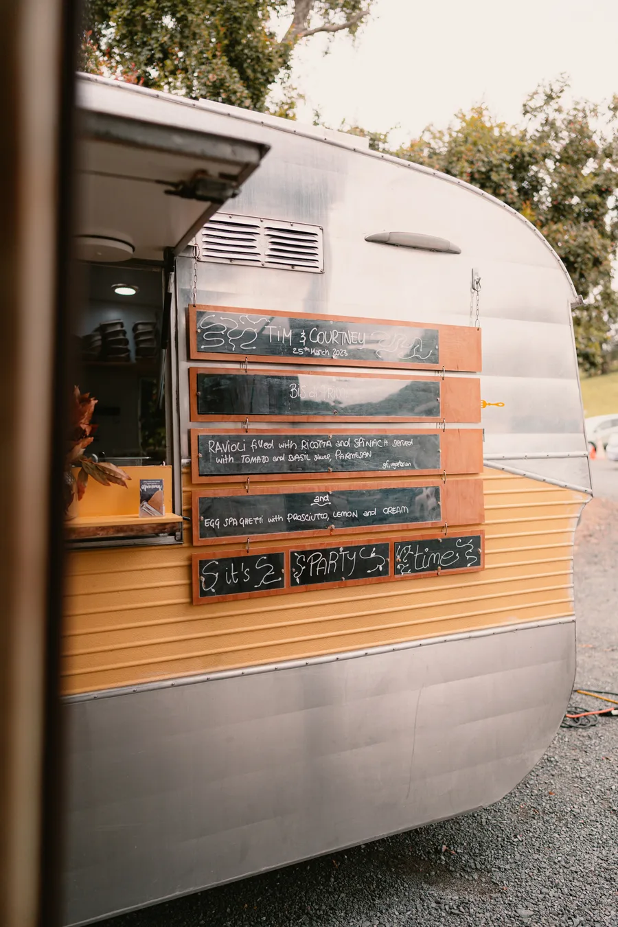 Personalised chalk menu board on the Amaranto caravan reading 'Tim & Courtney — It's Party Time'