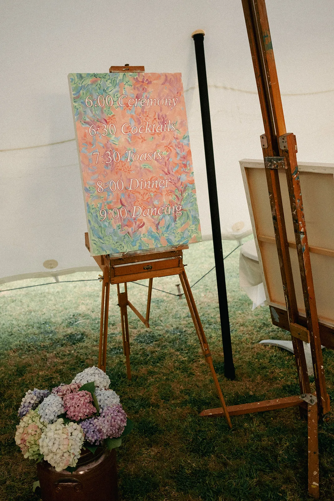 Hand-painted ceremony programme sign at Phaedra and Isaac's family home wedding in Matakana