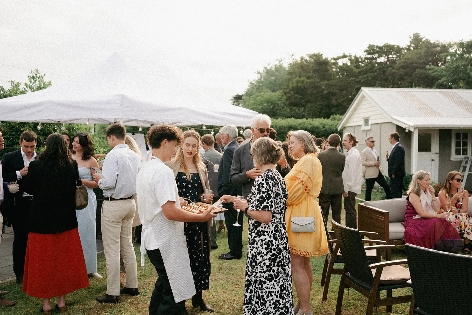 Guests raise their glasses in a toast at Phaedra and Isaac's wedding reception in Matakana