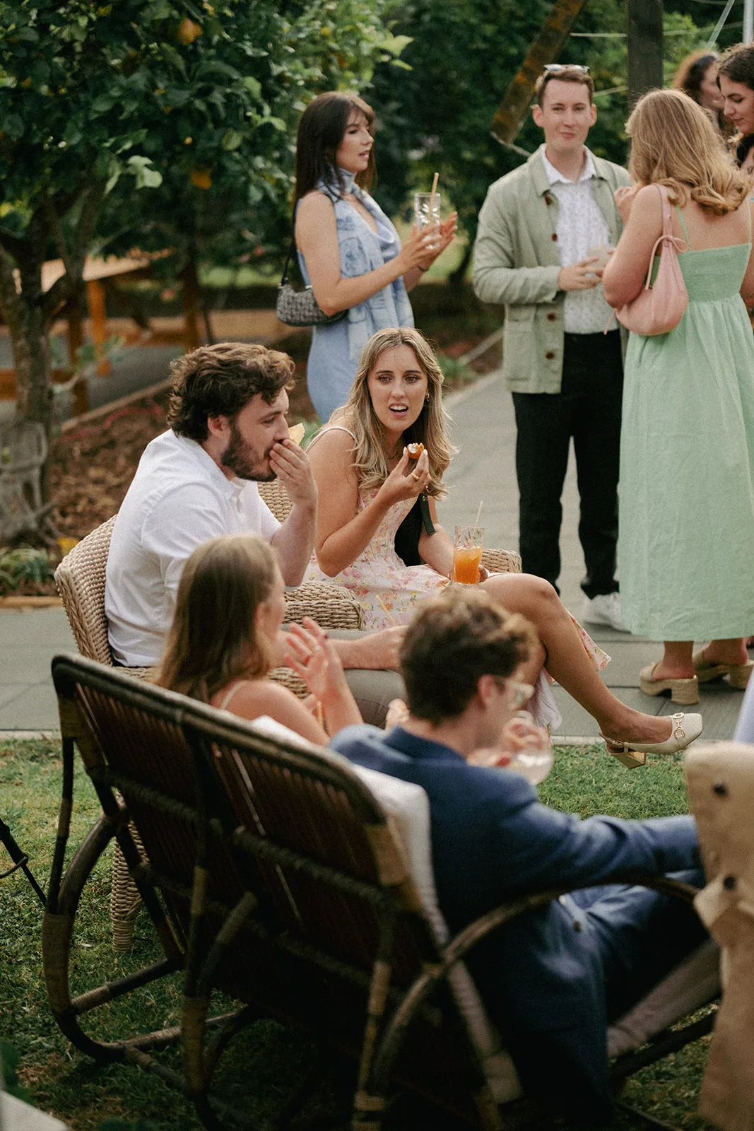 Amaranto wait staff passing trays of canapés to guests on the lawn at the Matakana family home wedding