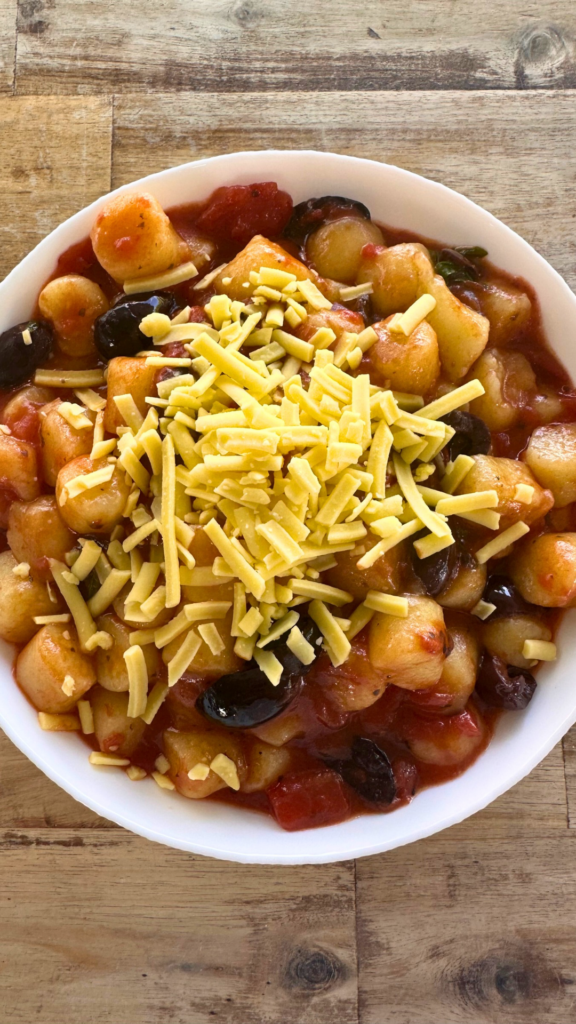 Potato gnocchi with tomato sauce, olives, garden herbs for a vegan gluten free wedding in Omaha